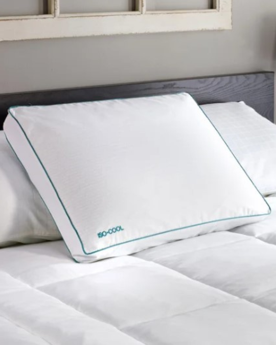 ISOCOOL side sleeper pillow on bed, close-up of Outlast Adaptive Comfort cotton cover, pillow with gusseted edge design, hand pressing into Serene foam pillow, removable washable pillow cover next to foam insert